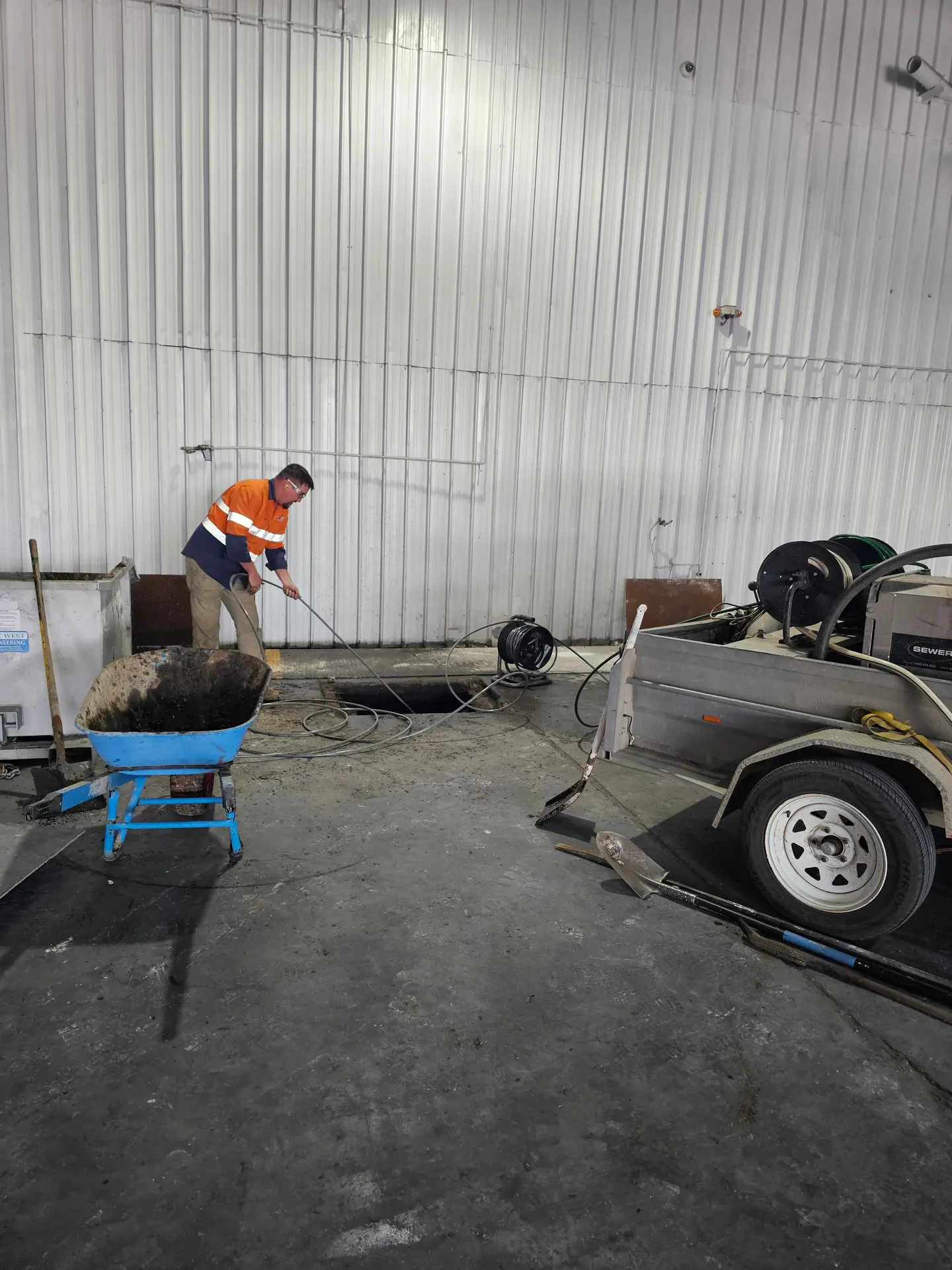 PVS Plumbing feeding a high-pressure jetting hose into a drain to clear a blocked line